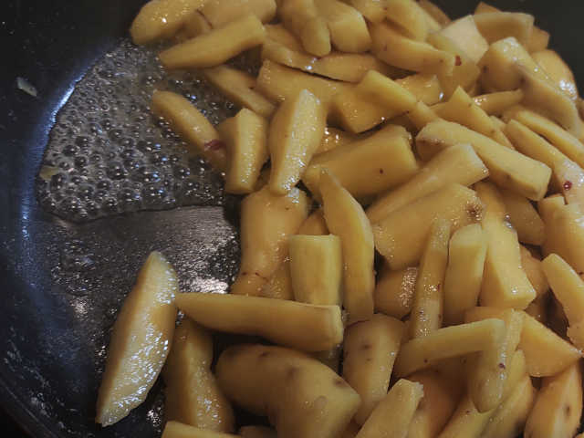 フライパンでさつまいもの揚げ焼きを作っている画像